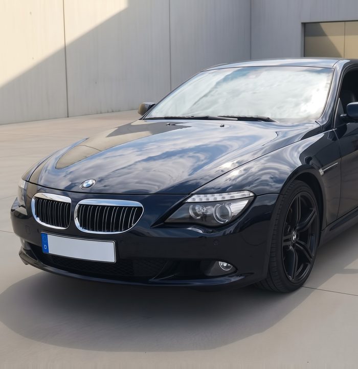 BMW 6er vorher im dunklen Werkslack, von vorn in einem Innenhof